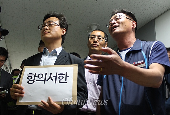  2일 오전 미군의 탄저균 국내 반입을 규탄하기 위해 부산미국영사관을 찾은 고창권 민주수호부산연대(왼쪽), 정한철 전교조 부산지부장(가운데), 김재하 민주노총 부산본부장(오른쪽)이 항의서한 직접 전달을 가로막는 영사관 보안담당자에게 항의하고 있다. 