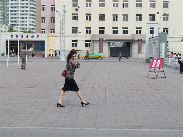 평양의 거리. 한 여성이 휴대전화 통화를 하면서 걸어가고 있다(2013년 9월 촬영분).
