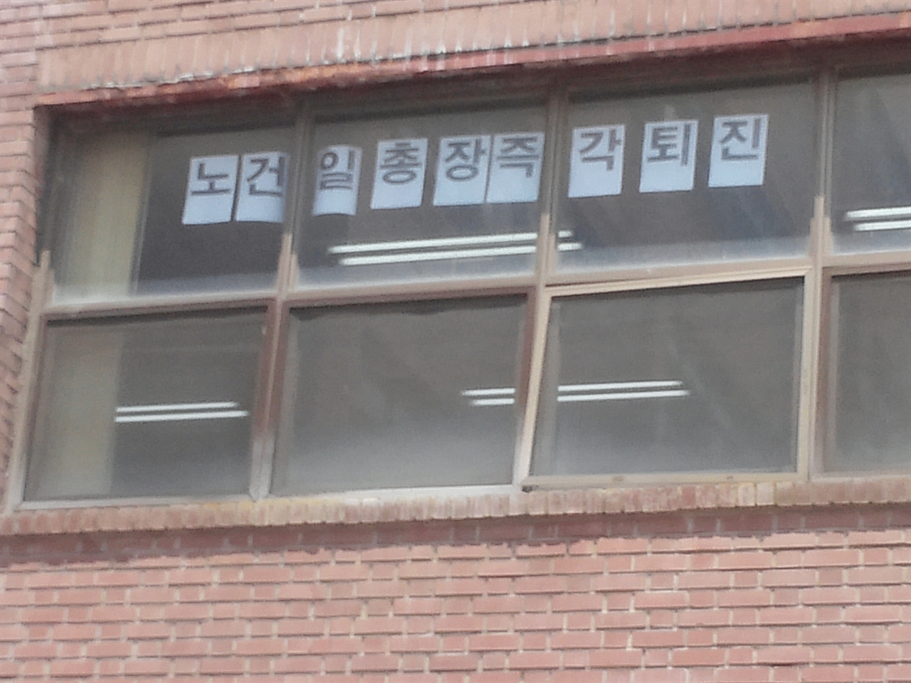 교수평의회 회의실 창문에 '노건일 총장 즉각 퇴진'이라는 글이 붙어 있다.