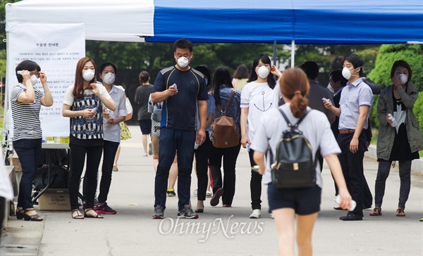 공무원들이 수험생들의 체온을 측정하기 위해 강남구 한 고사장 입구에서 대기하고 있다.