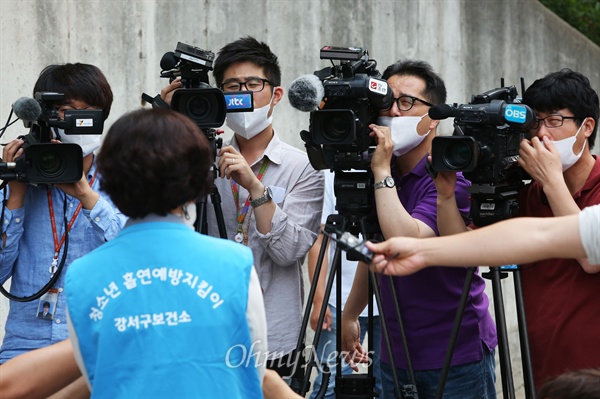 강서구 한 고사장 앞에서 마스크를 착용한 기자들이 보건소 직원을 인터뷰하고 있다.