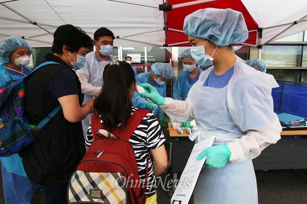  15일 오후 메르스 국민안심병원인 고대구로병원 응급실앞에 마련된 선별진료실에서 방역복을 착용한 의료진이 환자들의 체온을 확인하고 있다.