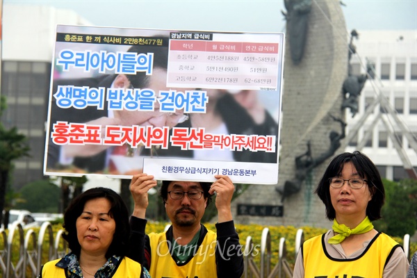  지난해 학교 무상급식 중단 사태가 계속되는 가운데, 학부모들이 경남도청 정문 앞에 손팻말을 들고 '무상급식 원상대로'를 외치고 있다.