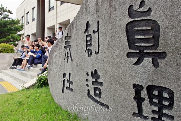 19일 오전, 전남대 학생들이 대학본부 앞에 앉아 대학본부의 재정위원회 구성안에 항의하고 있다.
