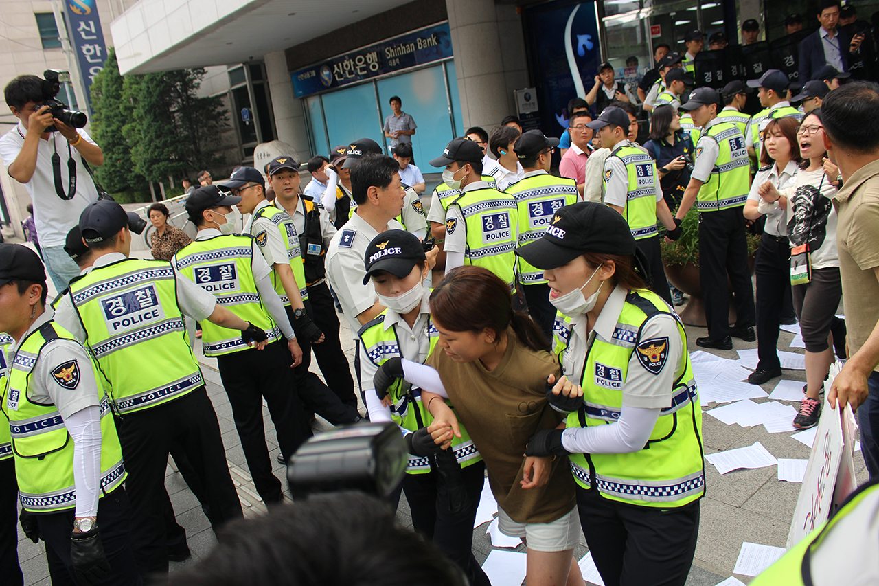 경총의 최저임금 동결에 분노한 알바노동자들이 25일 오전 서울 마포구 경총회관 앞에서 기습시위를 벌이자, 경찰들이 강제연행하고 있다. 