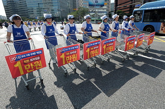 27일 오후 서울역 광장에서 개최된  '최저임금 1만원 쟁취 노동시장 구조개악 저지 전국노동자대회'에 참가한 홈플러스 노동자들이 '최저임금 1만원'을 요구하며 행진하고 있다.