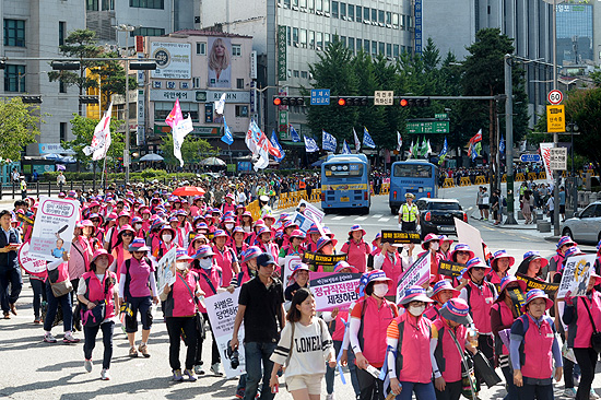 27일 오후 서울역 광장에서 개최된  '최저임금 1만원 쟁취 노동시장 구조개악 저지 전국노동자대회'에 참가한 노동자들이 '최저임금 1만원'을 요구하며 행진하고 있다.