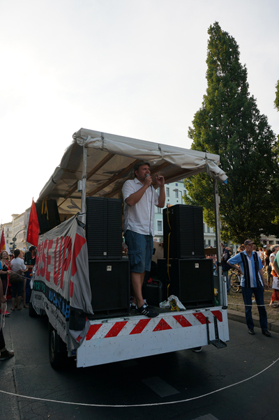 그리스 연대시위 집회 진행 차량 위에서 한 남성이 연설을 하고 있다.