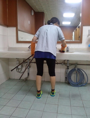 사수가 화장실 세면대의 물기를 제거하고 있다.
