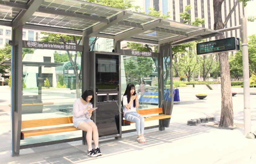 세종문화회관 앞 태양광 버스정류장에서 스마트폰과 태블릿PC를 충전하고 있는 시민들.
