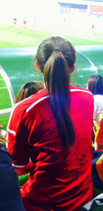  홈팀 인천현대제철 유니폼을 입고 경기장을 찾은 한 여성팬. 등에 선수들의 사인이 보인다.
