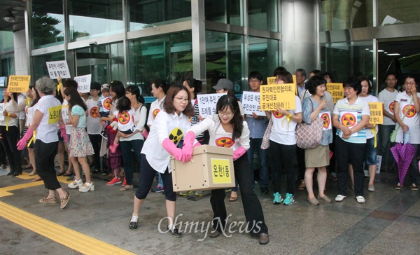  '대전 유성민간원자력환경안전감시기구 조례제정 청구운동본부'는 9일 오전 유성구청에 9450명이 서명한 '민간원자력시설환경·안전감시기구 조례제정청구인' 명부를 제출했다. 사진은 기자회견을 마친 후 주부들이 고무장갑을 끼고 청구인명부를 구청 민원실로 옮기는 퍼포먼스 장면.