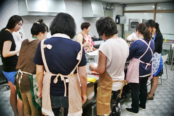 주부들이 수원 영동시장 문광현사업단이 주최한 요리강습을 받고 있다