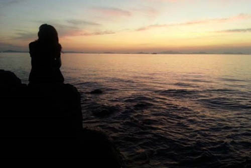 목포구등대 앞 매월리 앞바다의 일몰. 한 여인이 바위에 앉아서 일몰을 감상보고 있다.