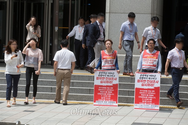 1인 시위 중인 김영미, 진모영 PD 주위로 점심식사를 위해 건물을 나오는 MBN 직원들이 지나가고 있다.