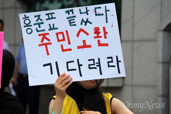 23일 오전 한 학부모가 경남도청 정문 앞에서 '홍준표 주민소환' 손팻말을 들고 서 있다.