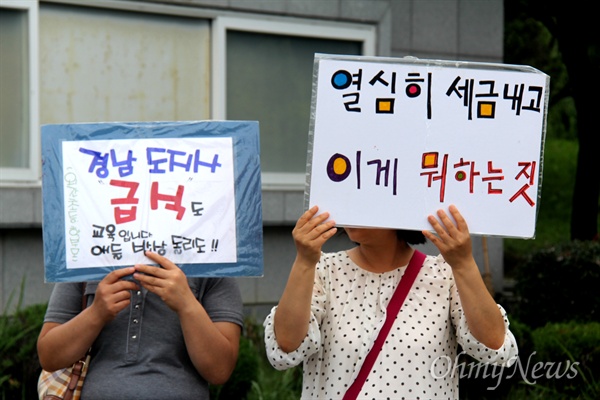  23일 오전 학부모들이 경남도청 정문 앞에서 '홍준표 주민소환으로 무상급식 원상회복' 손팻말을 들고 서 있다.