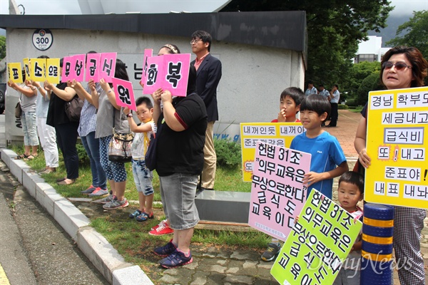 2015년 7월 23일, 학부모들이 경남도청 정문 앞에서 '홍준표 주민소환으로 무상급식 원상회복' 손팻말을 들고 서 있다.