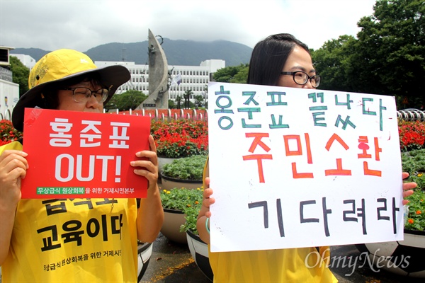  학부모들이 경남도청 정문 앞에서 '홍준표 주민소환' 손팻말을 들고 서 있다.