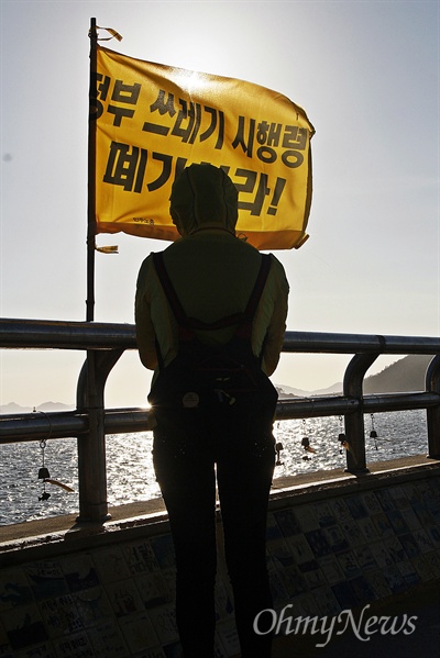 이날 팽목항을 찾은 한 시민이 '정부 쓰레기 시행령 폐기하라'라고 적힌 방파제의 깃발 앞에 서서 바다를 바라보고 있다.
