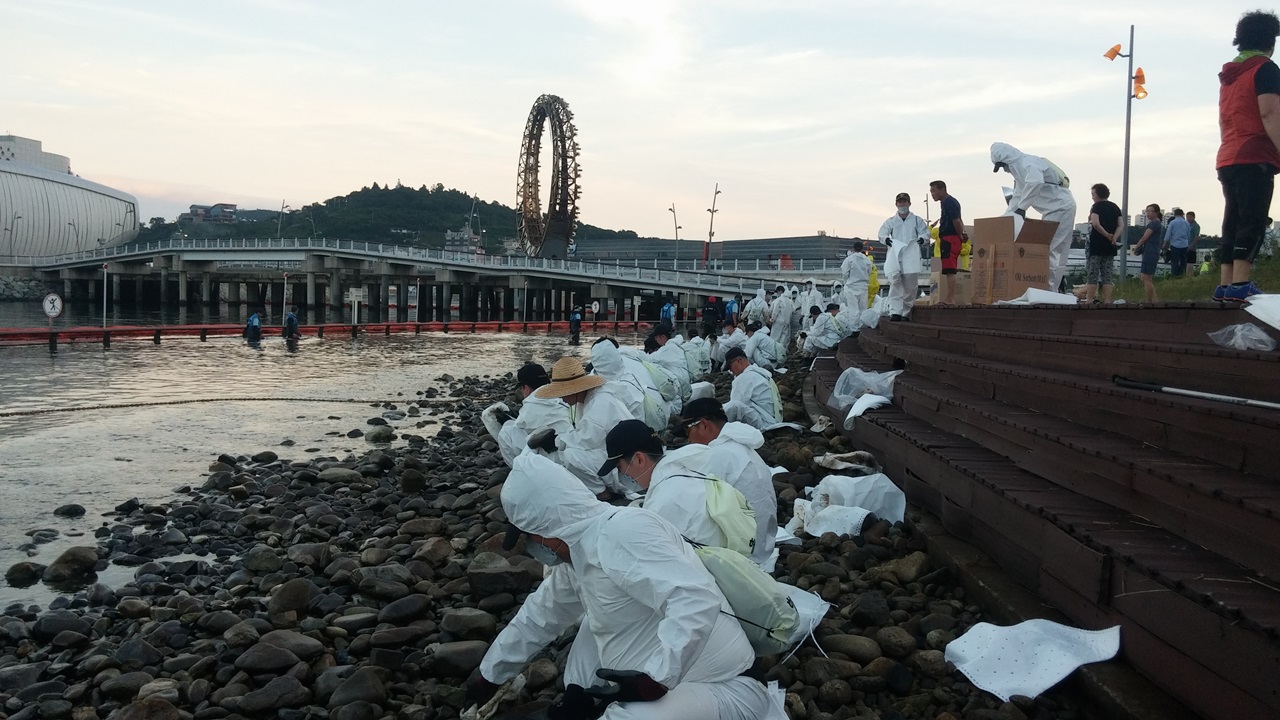 26일 여수세계박람회장에서 원인을 알 수 없는 기름이 유출돼 출동한 공무원들이 방제작업을 펼치고 있다.