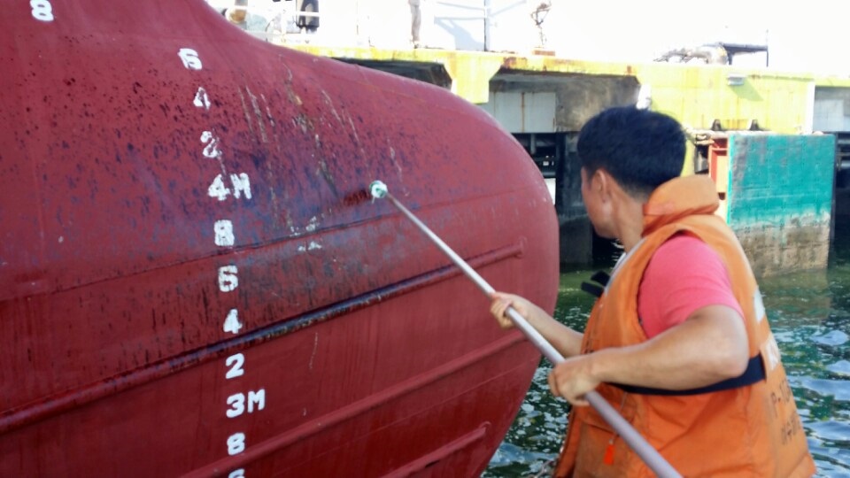 여수세계박람회장 해안을 오염시켜 물의를 일으킨 1500톤급 캐미칼 운반선 Y호의 선수에 기름유출 흔적이 선명한 가운데 해경이 샘플을 채취하고 있다.