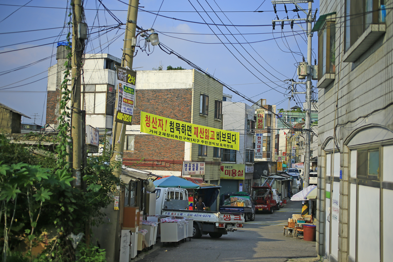 거여동재개발지구 2-1지구 거여동재개발지구의 본격적인 이주와 2015년 11월에 착공할 예정으로 진행되는 재개발사업이 지역주민들과의 마찰을 불러일으키고 있다. 2005년 재개발지구로 선정된 이후 십년의 세월, 지금까지 그곳을 지켜온 지역주민들은 현재의 개발방식대로 한다면 자신들의 재산이 반토막 난다고 주장하고 있다.
