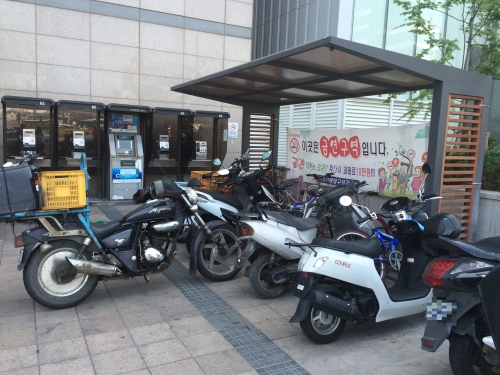수원역 앞 자전거 보관함에 오토바이가 세워져 있다.
