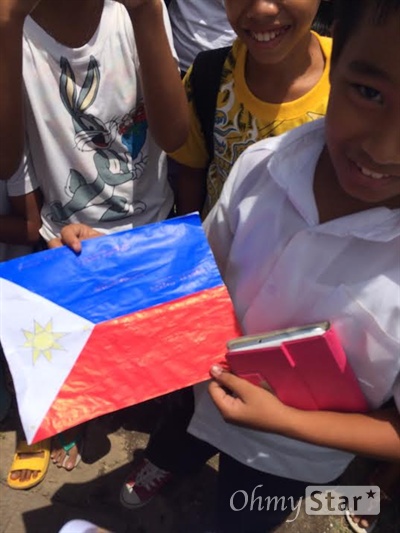  취재진에게 자신이 직접 만들었다며 필리핀 국기 모형을 보여주고 있는 한 소년.