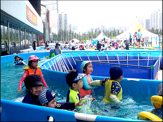 세찬 물결따라 어린이들이 빙글빙글 돌아가며 물놀이를 즐기고 있다. 