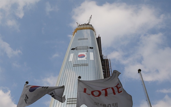 서울 송파구 롯데월드타워에 5일 오후 광복70주년을 맞아 대형 태극기 게시 작업이 한창이다. 롯데물산은 이번 초대형 태극기의 펼친 넓이는 864㎡(약 262평)로, 국내 최고의 높이에 부착되는 기록을 세우게 될 것으로 전망했다.