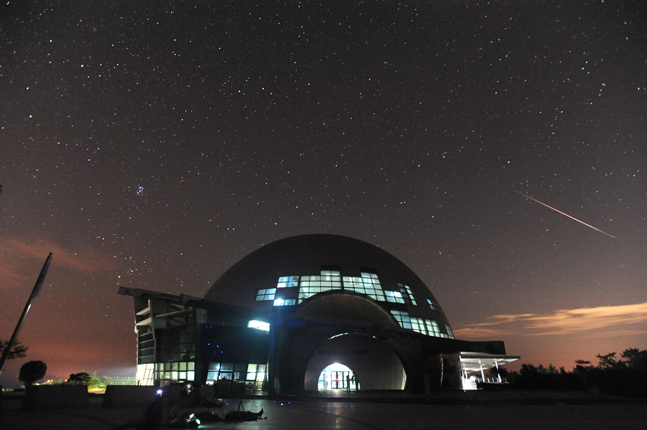 페르세우스 유성우가 국립고흥청소년우주체험센터 상공을 청아하게 비행하고 있다. 중앙 왼쪽에는 플레이아데스 성단이 화려하게 빛나고 있다.