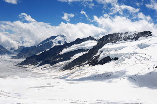 흰구름날고  만년설이 덮여 있는 알프스 고봉 융푸라오요흐의 모습