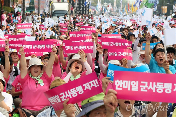 15일 오후 서울 대학로에서 열린 8·15 반전평화 범국민대회 참가자들이 '한미일 군사동맹 저지' 손팻말을 들어보이고 있다.