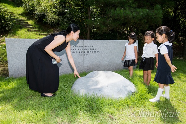 17일 오전 경기도 파주 장준하공원에서 열린 고 장준한 선생 40주기 추모식에서 고 장준하 선생의 손녀 정아씨가 증손녀 양혜리, 양채리, 박예나양에게 <돌베개>에 대해 설명하고 있다. 