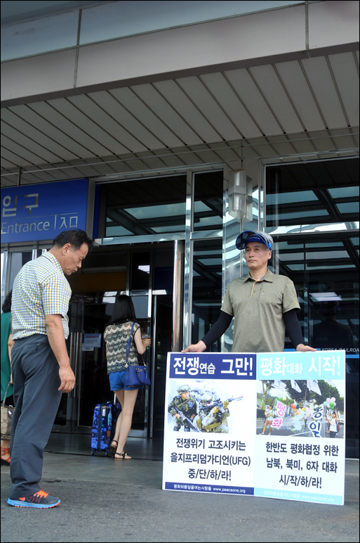 기자회견을 개최한 단체들은 UFG연습 기간(8월 17일부터 ~28일)동안 대전전역광장 등에서 1인시위를 진행할 계획이다. 대전역을 지나가는 시민이 1인시위 피켓을 유심히 바라보고 있다.