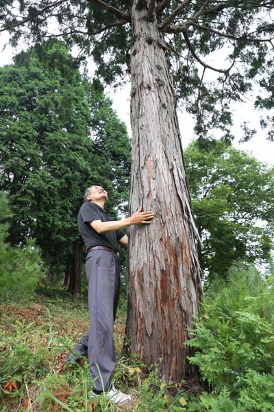 정은조 대표가 지난 11일 윤제림에서 아름드리 자란 나무를 부둥켜 안고 흐뭇한 표정을 짓고 있다. 