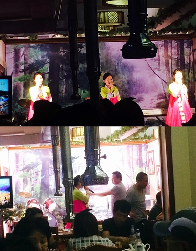식당 앞 작은 무대에서 노래하는 북한 종업원들