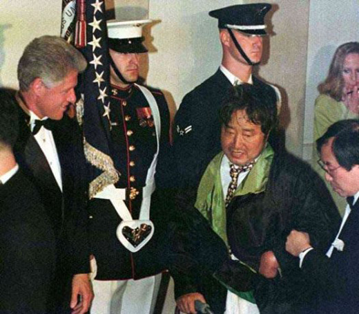 백악관 만찬장(1998년 6월 2일)에서 백남준과 악수하다 그의 바지가 흘러내린 걸 보고 당황해하는 클린턴대통령