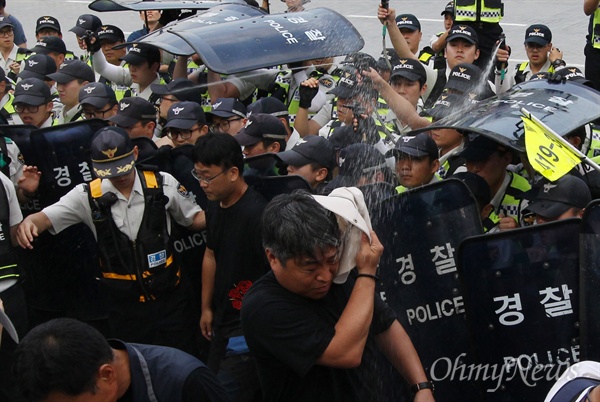 민주노총 조합원들이 8월 28일 오후 서울 종로구 정부서울청사 앞 도로를 점거한 채 '노동시장구조개악저지 집중행동' 대회를 진행하자, 경찰이 이를 저지하기 위해 참석자 얼굴을 향해 캡사이신을 조준발사하고 있다.