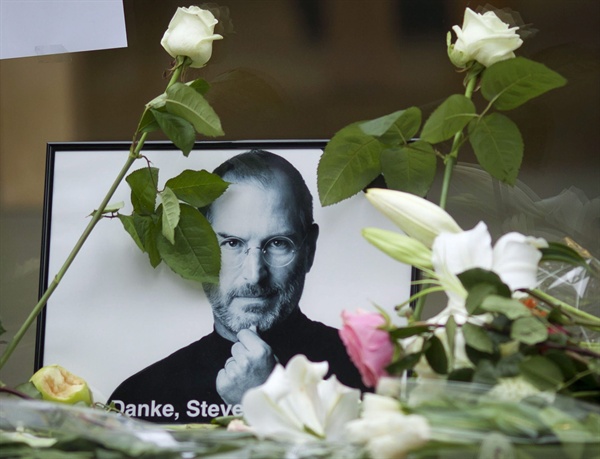 지난 2011년 10월 6일(현지시간) 독일 프랑크푸르트의 애플 스토어에 스티브 잡스의 사진과 그를 추모하기 위한 꽃들이 놓여 있다. 잡스는 지난 2011년 10월 5일 향년 56세의 나이로 사망했다.
