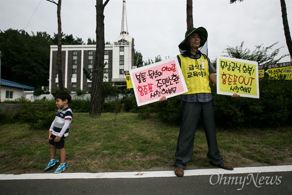   '제1회 경상남도지사배 공무원골프대회'가 5일 창녕 동훈힐마루골프장에서 치러진 가운데, 학부모들이 골프장 입구에서 규탄 집회를 열고 있다. 