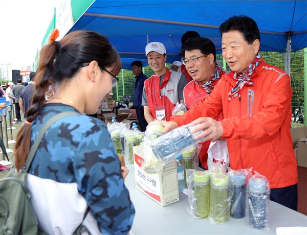 12일 열린 '창원시 둘레길 걷기대회' 때 안상수 창원시장이 참가자들한테 물병을 나눠주고 있다.
