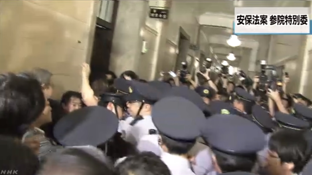 안보법안 참의원 특별회원회 개최를 둘러싼 일본 여야 의원들의 몸싸움을 보도하는 NHK 뉴스 갈무리.