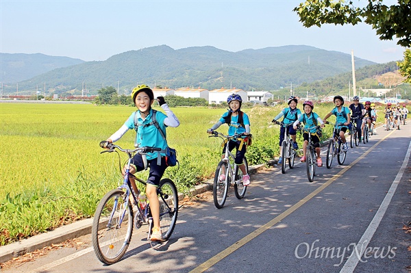11일 인안초등학교의 5학년 학생들이 '도전활동 프로젝트'인 철인 2종 경기를 하기 위해 자전거를 타고 학교를 나서고 있다.