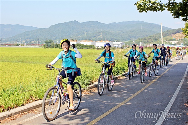 철인 2종 경기, 도전! 11일 인안초등학교의 5학년 학생들이 '도전활동 프로젝트'인 철인 2종 경기를 하기 위해 자전거를 타고 학교를 나서고 있다.