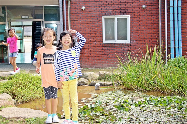 11일 찾은 인안초등학교의 학생들이 학교 연못에서 카메라를 보며 웃고 있다.