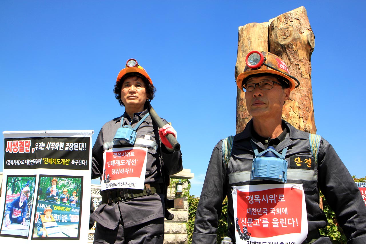 성희직(오른쪽) 진폐제도개선위원장이 지난 15일 국회 앞에서 갱목 시위를 하고 있다. 