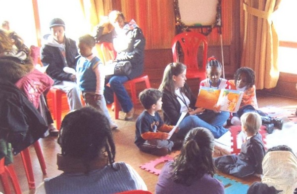 난민학교에서 아이들이 자원봉사자들과 함께 책을 보며 놀고 있다.