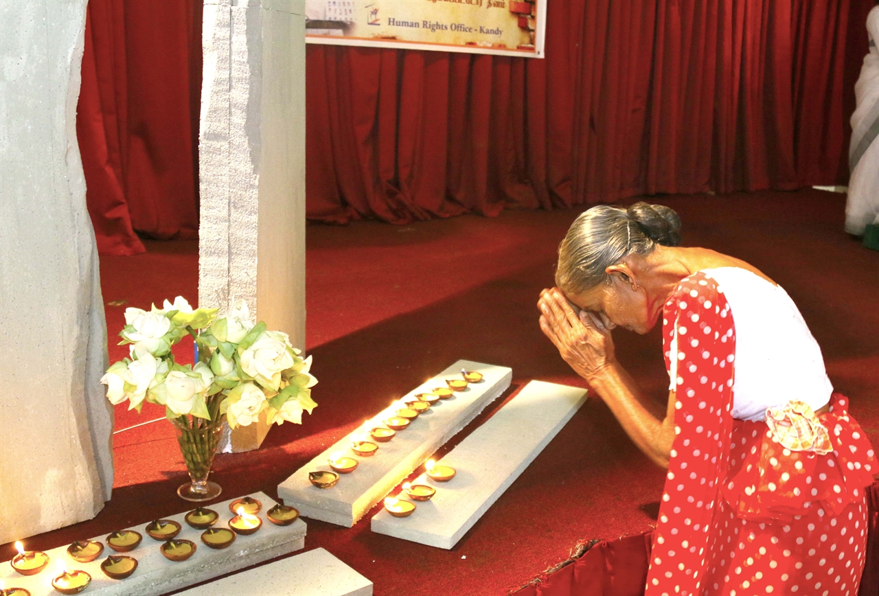 스리랑카 내전 기간 중 자식이 실종된 어머니가 초에 불을 키며 기도를 올리고 있다. 